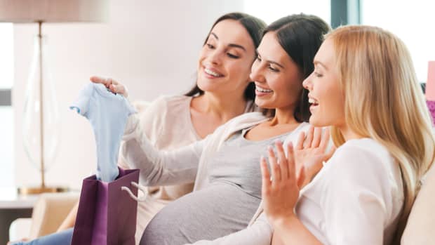 woman opening baby shower gifts