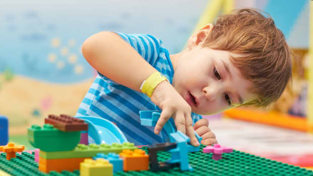 child playing and building with colorful plastic bricks table. Early learning and development.