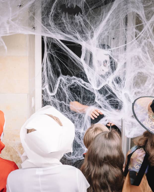 trick or treaters behind spider web
